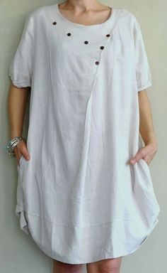 "A boho casual chic short sleeve cotton mix linen dress/tunic with curved hem. - Silhouette- - Loose fit body - Short sleeves - Pleated front dress - Curved hem - Hidden pockets in side seams of the dress - Body length - 94cm/37\" (longest part) Model is 161 cm. tall with the waist of 28\" and the hip of 38\" Status: ready to ship Weight: 302g Measurement: Tunic /dress (approximately) Shoulder: 16.25\" Bust: 42\" **can fit upto bust max38\" Armhole: 22\" Sleeve: 9\" Hip: 48\" **can fit upto bust Short Sleeve Linen Dress With Buttons For Day Out, Casual Half Sleeve Tunic For Spring, Short Sleeve Beige Linen Dress For Spring, Beige Linen Short Sleeve Dress For Spring, Beige Linen Short Sleeve Dress For Summer, Beige Short Sleeve Linen Dress For Summer, Beige Short Sleeve Linen Dress For Vacation, Spring Beige Linen Dress With Short Sleeves, Summer Cotton Tunic With Short Sleeves