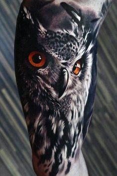 an owl with orange eyes is shown on the left side of his arm and chest