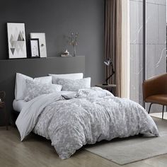 a bedroom with grey walls and white bedding