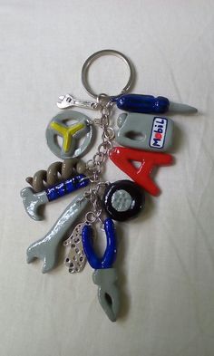 a keychain with various tools on it sitting on a white cloth covered table