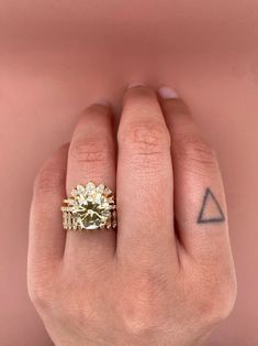 a woman's hand with a yellow diamond ring on top of her left hand