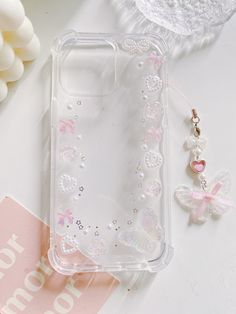 a clear case with pink and white butterflies on it, next to a flower bouquet