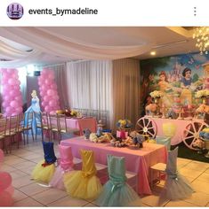 there is a table set up with princess decorations and balloons on the wall behind it