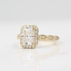 an engagement ring with a cushion cut diamond in the center