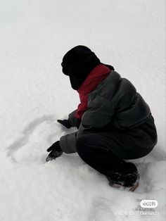 a person sitting in the snow on their knees