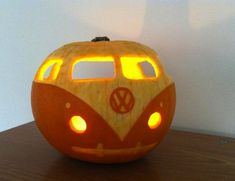 a carved pumpkin with a vw bus on it's face and lights in the eyes