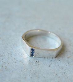 925 silver asymmetric solid ring with three sapphires. uniqe unisex engagement ring. * The ring is 4 mm - 6 mm in width. * Can be ordered in 14k gold - 455$ * sapphires size - 1.5 mm. * Can also be ordered in 18k gold - please contact me for details. * Finish- Matte or Shiny. * Can be made in yellow, white or rose 14k gold. * This price is for a ring in a size up to 9, if you need a bigger size > contact me for price & details. * All jewelry will be sent in a beautiful gift box. * Handmad Modern Sterling Silver Sapphire Ring For Formal Occasions, Sapphire Signet Ring With Polished Finish For Promise, Sapphire Signet Ring With Polished Finish, Silver Sapphire Ring With Vs Clarity For Promise, Modern Silver Sapphire Ring For Anniversary, Modern Sapphire Signet Ring For Anniversary, Modern Sapphire Ring With Polished Finish For Promise, Modern Sterling Silver Sapphire Ring, Modern Polished Sapphire Promise Ring