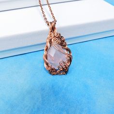 Lovely pale pink rose quartz is accented by dark copper woven wire that artistically frames it. This is a substantial statement pendant that would compliment a variety of styles and colors in any woman's wardrobe. The pendant measures 2 inches by 1 inch and comes with a FREE coordinating chain with lobster claw clasp, measured to your preferred length. Your unique pendant is ready to ship via USPS to your US location at no extra cost. (International shipping available. Please be aware of your lo Handmade Rose Quartz Jewelry In Rose Gold, Pink Wire Wrapped Copper Jewelry, Pink Copper Wire Jewelry For Gifts, Pink Copper Wire Wrapped Jewelry, Handmade Pink Copper Wire Jewelry, Pink Wire Wrapped Copper Wire Jewelry, Bohemian Rose Gold Rose Quartz Jewelry, Gold Wire Wrapped Rose Quartz Jewelry, Rose Quartz Wire Wrapped Necklace As Gift