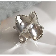 a silver ring sitting on top of a white surface