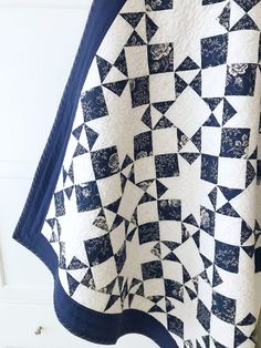 a black and white quilt hanging on a wall