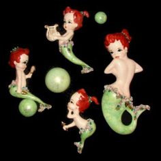 four little mermaid figurines sitting next to each other on top of a green ball