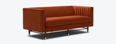 an orange velvet sofa with gold legs