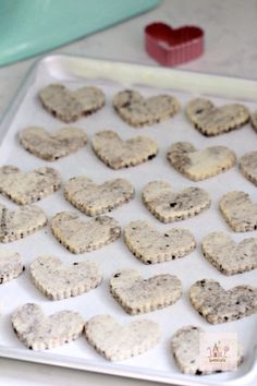 heart shaped cookies sitting on top of a cookie sheet