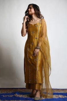 Burnt gold straight kurta in dupion silk base with zari and sequins hand embroidered tiered motifs. Comes with wide legged pant and an organza dupatta.
Component: 3
Pattern: Embroidered
Type Of Work: Zari, Sequins
Neckline: Round
Sleeve Type: Sleeveless
Fabric: Kurta and Pant : Dupion Silk, Dupatta : Organza 
Color: Gold
Other Details: 
Closure : Pant : Fixed belt at front and elastic at back, Opening on the side with a Zip and Hook
Occasion: Mehendi and Haldi, Sangeet - Aza Fashions Lehanga Idea, Silk Kurtis, Kurtis Design, Stylish Kurtis, Ethnic Dresses, Clothing Wishlist, Long Kurta, Gaun Fashion, Azul Tiffany