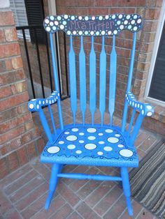 a blue rocking chair with polka dots painted on it