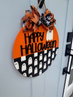 a door with a happy halloween sign hanging on it's side and ghost decorations