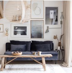 a living room with pictures on the wall and a couch in front of a coffee table