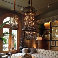 a living room filled with lots of furniture and chandelier hanging from the ceiling