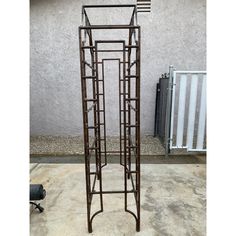 a tall metal plant stand next to a wall