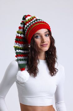 a woman wearing a knitted hat with pom - poms on her head