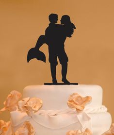 the silhouette of a man and woman on top of a wedding cake with rose petals