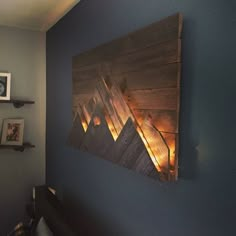 a wooden wall hanging on the side of a blue wall in a room with pictures