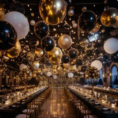 a large room filled with lots of tables covered in gold and silver balloons hanging from the ceiling