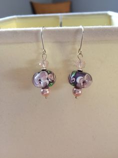 The one of a kind earrings feature a gorgeous purple lampwork bead with pink flowers, complimented by a light pink glass bead, pink Swarovski crystal pearl and sterling silver disc-shaped spacer bead on a sterling silver earring wire.   To see my other earrings: https://www.etsy.com/ca/shop/SimpleEleganceByJ?ref=condensed_trust_header_title_sold&section_id=20163243 To check out the rest of my shop: https://www.etsy.com/ca/shop/SimpleEleganceByJ Thanks for stopping by! Pink Glass Round Jewelry, Pink Flower Glass Jewelry, Pink Round Glass Jewelry, Pink Flower-shaped Glass Jewelry, Pink Beaded Pearl Drop Earrings For Gift, Pink Pearl Drop Beaded Earrings For Gifts, Elegant Pink Round Bead Flower Earrings, Elegant Pink Czech Glass Earrings, Elegant Pink Czech Glass Jewelry