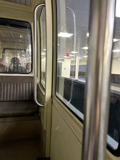 an empty train car with the door open and people sitting in seats looking out the window