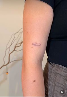 a woman's arm with a small tattoo on the left side of her arm