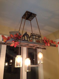 the lights are hanging from the ceiling above the windows in the kitchen, which is decorated with fall leaves and mason jars