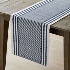 a blue and white striped table runner on a wooden table