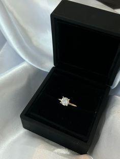 an engagement ring in a black velvet box