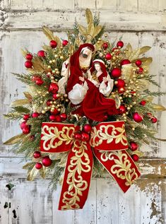 a christmas wreath with an image of mary and jesus in red, gold and white