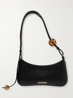 The curved shape of Jacquemus' 'Le Bisou Perle' bag is timelessly elegant. Crafted from smooth leather, it's embellished with resin spheres at each end of the sleek shoulder strap. The gold-tone hardware is polished for subtle shine. Shoulder Bags Outfit, Jacquemus Bag, Iconic Bags, Black Shoulder Bag, Purse Accessories, Purses Designer, Cute Bags, Black Bag, Smooth Leather