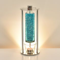 a glass bottle with blue glitter inside sitting on a table