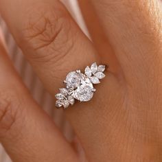 a woman's hand with a diamond ring on top of her finger and an engagement band