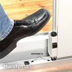 a person wearing black shoes and jeans stepping on a sliding door with their feet propped up