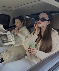 two women sitting in the back seat of a car