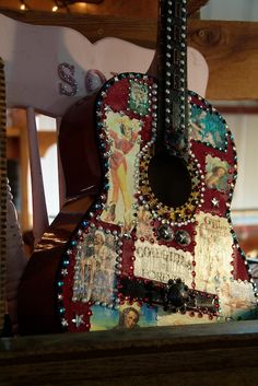 an old guitar is decorated with many different things