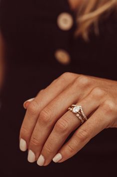 a woman's hand with two rings on it