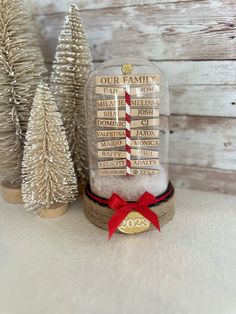 a snow globe sitting on top of a table next to small christmas trees and decorations