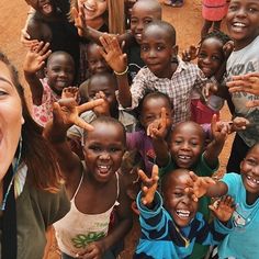 a group of children posing for a photo with their hands in the air and smiling