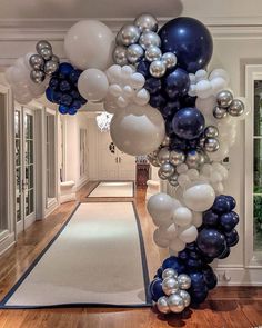 a hallway decorated with balloons and streamers in blue, white and silver colors for a party