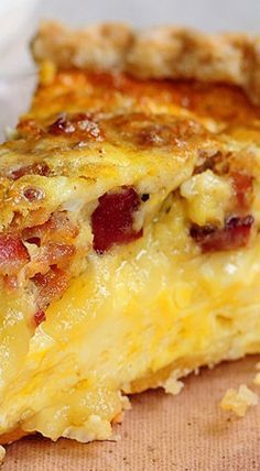 a piece of quiche sitting on top of a wooden cutting board