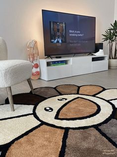 a living room with a flat screen tv sitting on top of a hard wood floor