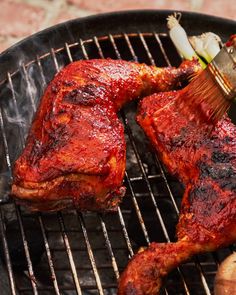 the meat is being grilled on the grill with a brush in it's mouth