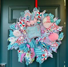 a wreath that says sweetest is hanging on a door with candy canes and candies