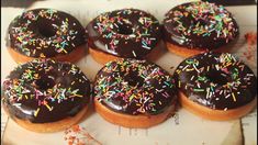 six donuts with chocolate frosting and sprinkles