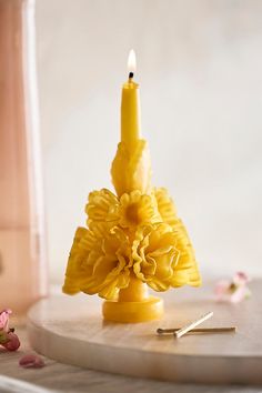 a yellow candle sitting on top of a table